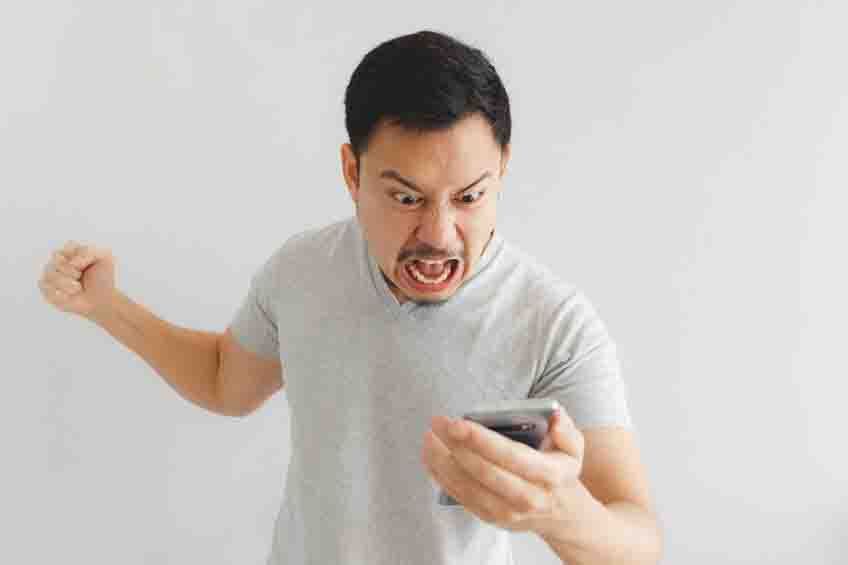 Angry man in grey t-shirt get mad on the smartphone.